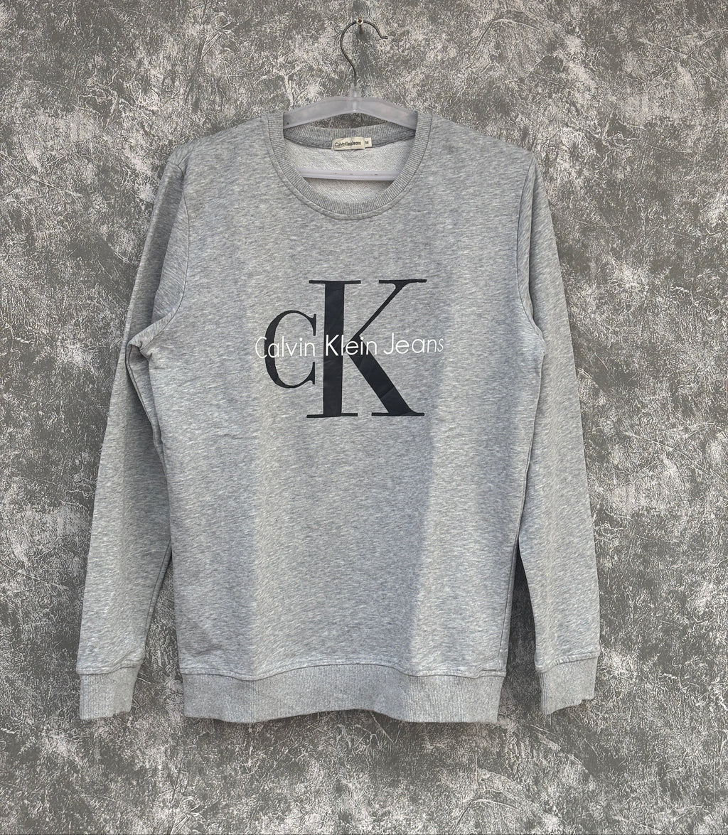 Gray sweatshirt with Calvin Klein logo on a textured surface